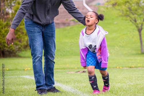 A young girl is learning how to play soccer 