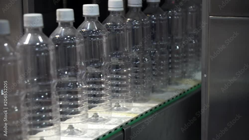 The new plastic bottles in the conveyor belt at the drinking factory. The new plastic bottles in the conveyor belt at the drinking factory.