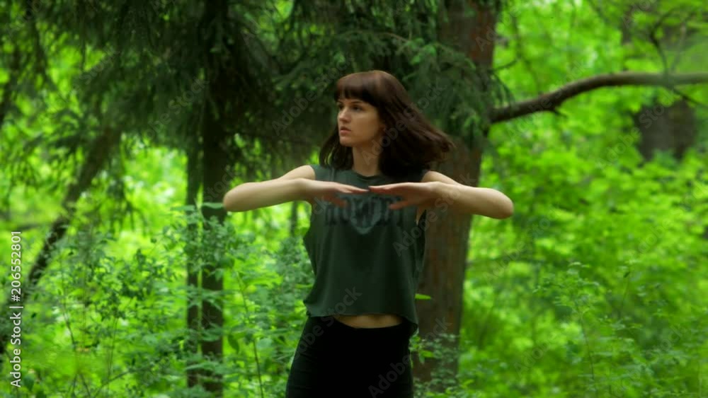 Pretty young girl does fitness exercises in the summer forest Pretty young girl does fitness exercises in the summer forest