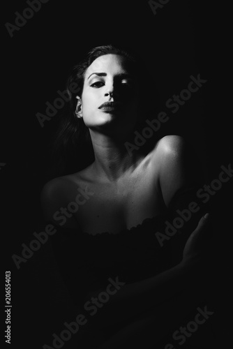 Young brunette woman in black lingerie in chiaroscuro lighting photo