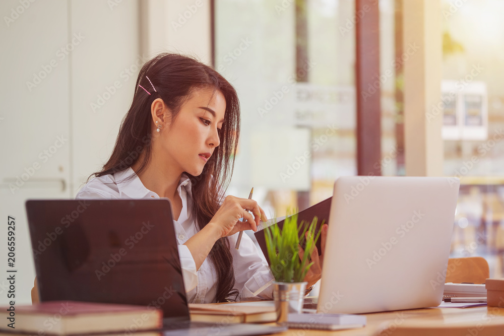 Female employee working on project in office. Female employee working on project in office.