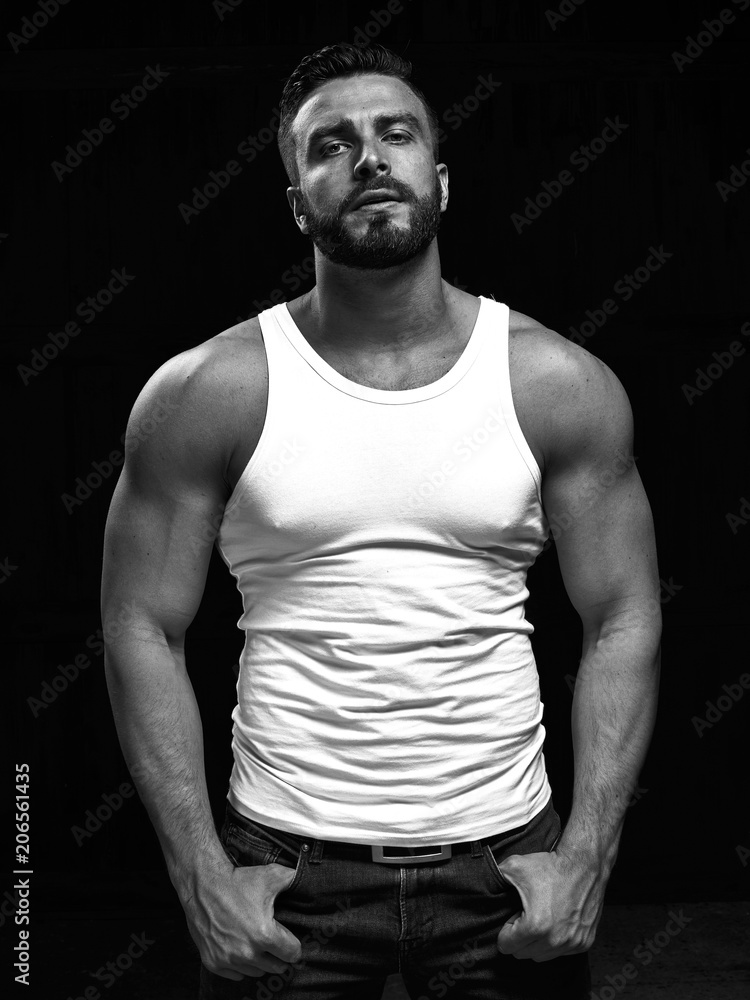 Monochrome portrait of a strong man with a beard. He looks at the camera with different emotions. Monochrome portrait of a strong man with a beard. He looks at the camera with different emotions.