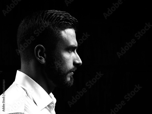 Monochrome portrait of a strong man with a beard. He looks at the camera with different emotions. 