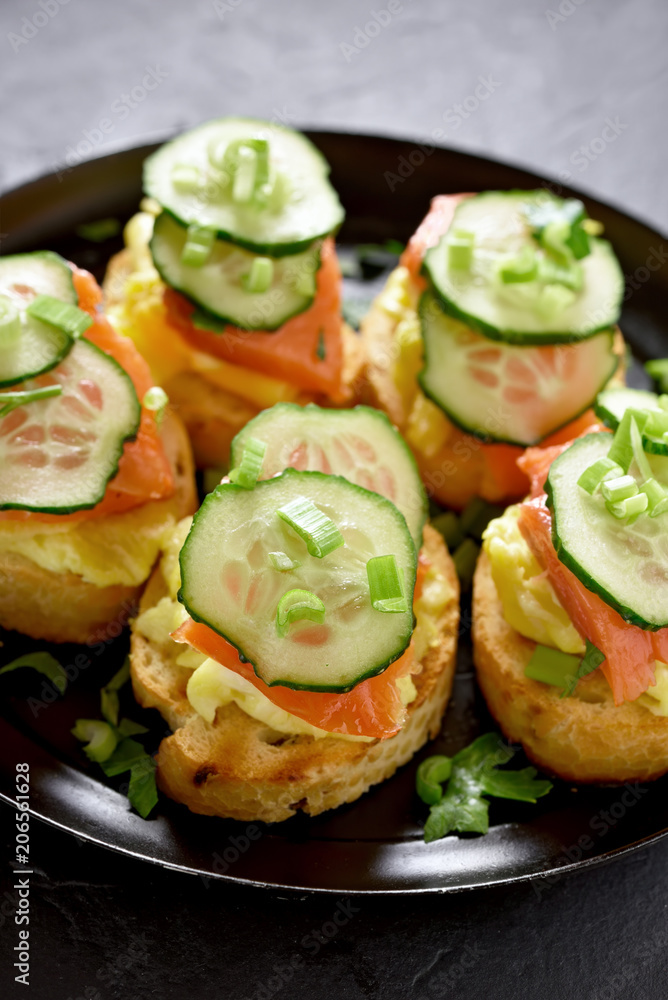 Sandwiches with salmon, scrambled eggs and cucumber Sandwiches with salmon, scrambled eggs and cucumber