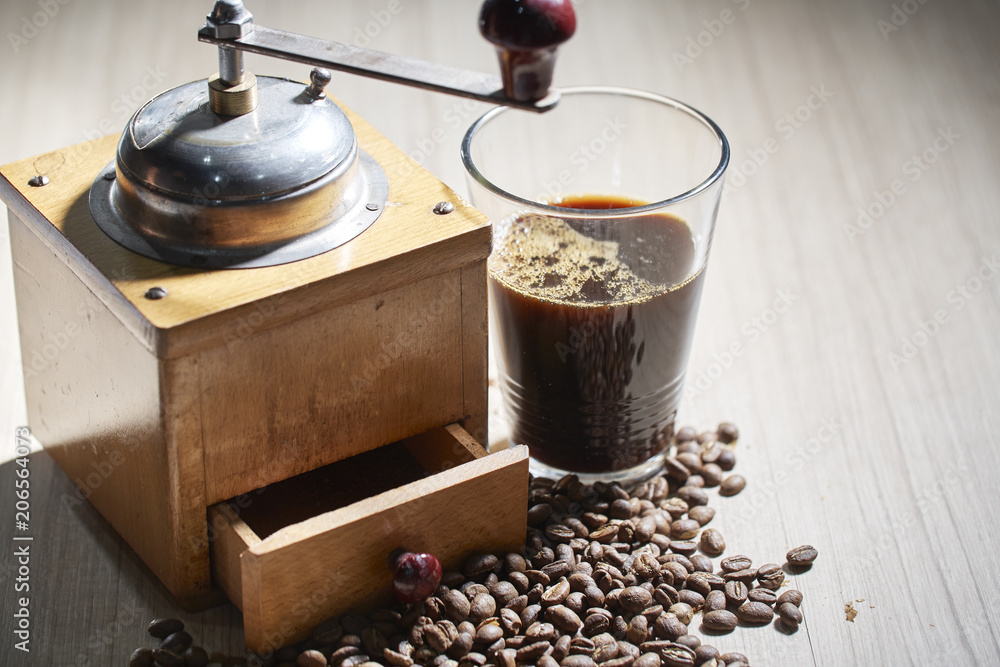 Black coffee with coffee grinder placed