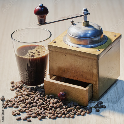 Black coffee with coffee grinder placed