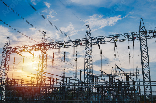 Sunset behind substation towers with blue sky photo