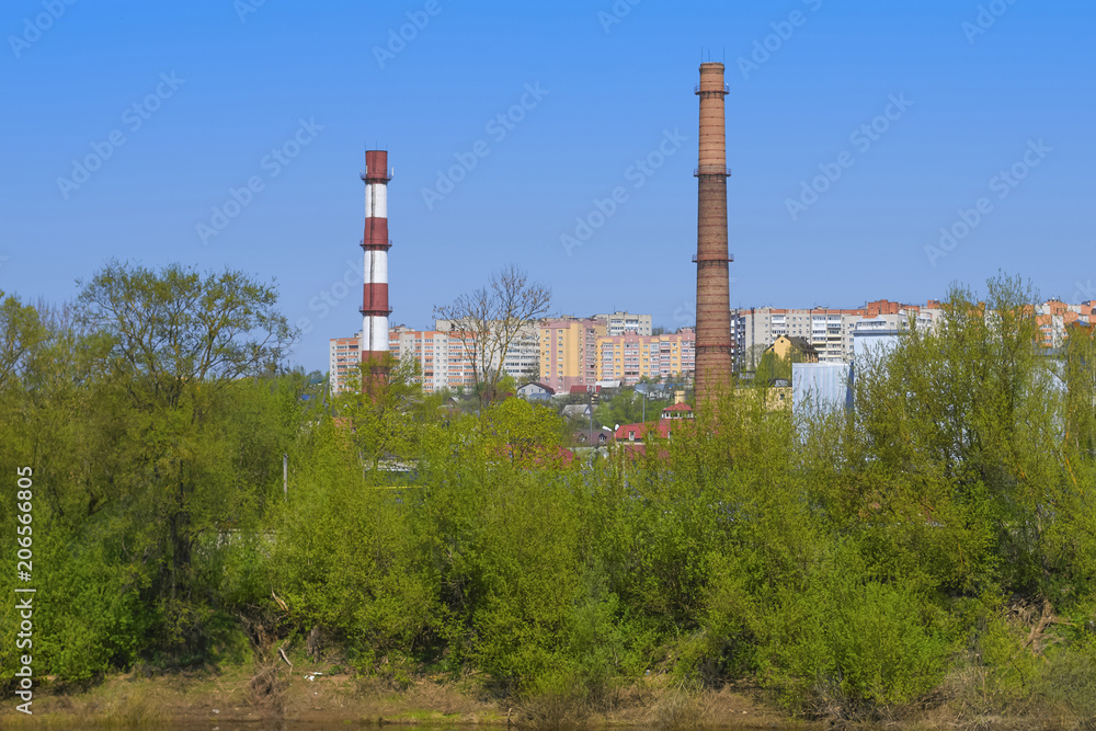 Industrial landscape with factory pipes against the blue sky and