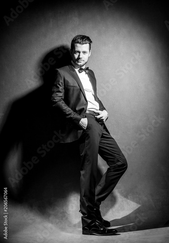 portrait of confident handsome man in black suit with bowtie