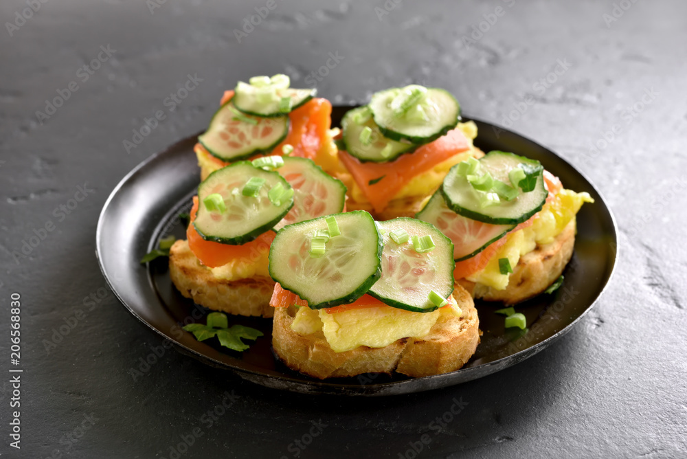 Sandwiches with salmon, scrambled eggs and cucumber Sandwiches with salmon, scrambled eggs and cucumber