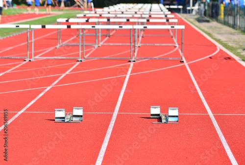 A hurdle race on red running in stadium track; success concept.