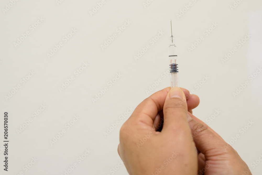 Close up doctor's hand holding syringe for vaccination woman patient.Vaccine for protection concept Close up doctor's hand holding syringe for vaccination woman patient.Vaccine for protection concept