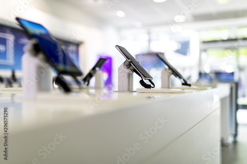 Close up of cell phones or mobile phones on display in a modern, clean and contemporary shop or mall photo