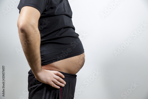 Bild auf Leinwand Adult man is showing his fat, unhealty belly
