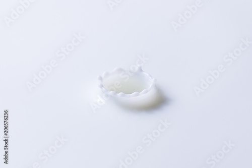 Drop falling on milk, cream, dairy product. Yogurt milkshake swirl texture. Graphic design element for packaging, advertisement flyer, poster. Cream splash with circle ripple and drop.