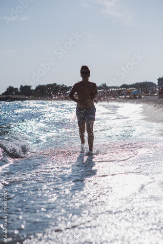 Boy running in water on the beach