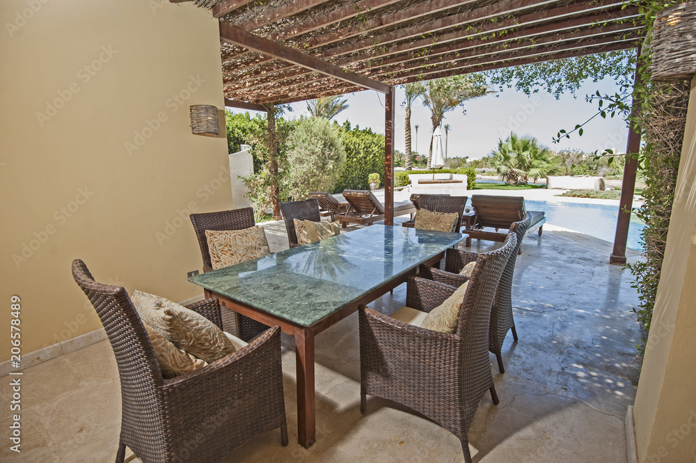 Obraz premium Swimming pool and outdoor dining area at at luxury tropical holiday villa resort