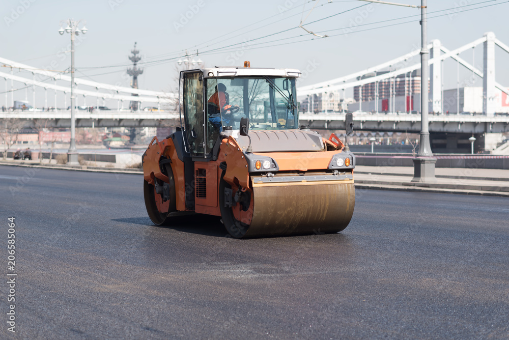 Asphalt roller that stack and press hot asphalt. Road repair machine road repairing in urban modern city with heavy vibration roller compactor Asphalt roller that stack and press hot asphalt. Road repair machine road repairing in urban modern city with heavy vibration roller compactor