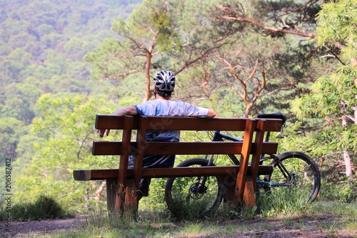 Mountainbiker macht Pause auf einer Bank