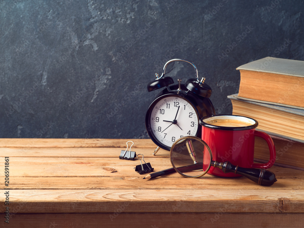 Coffee cup, alarm clock and old books on vintage wooden table Coffee cup, alarm clock and old books on vintage wooden table