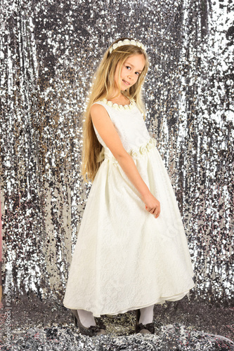 Stunning beauty young girl model in the white communion dress stands in an elegant pose