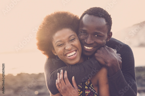 beautiful black race nice model couple man and woman young age hug and stay together with love and friendship. outdoor scenic place near the beach for vacation or lifestyle.