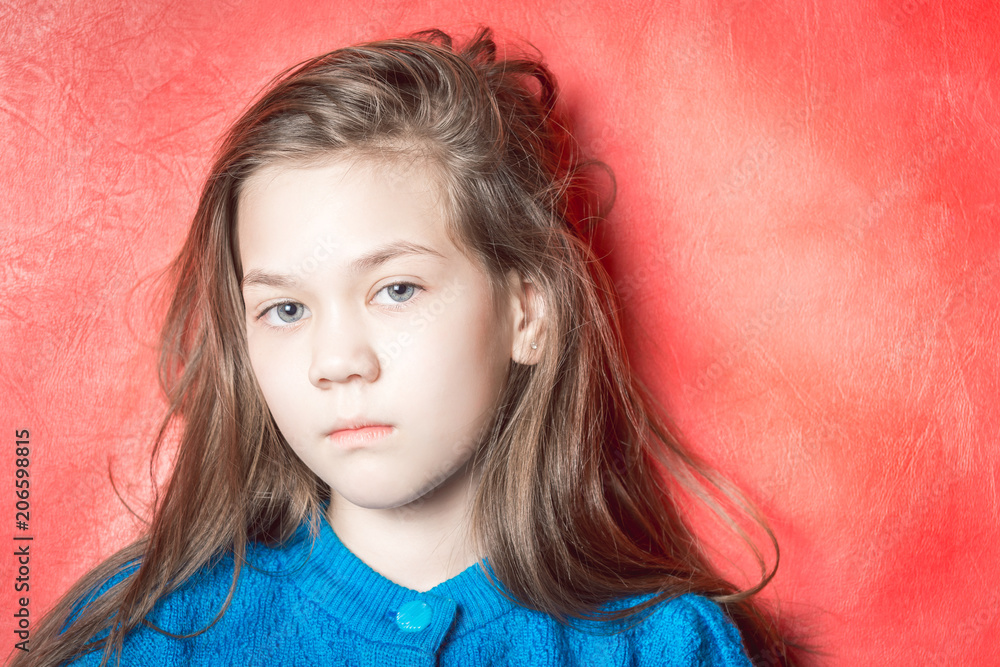 Sad girl in a blue sweater on a red background Sad girl in a blue sweater on a red background