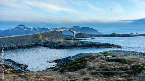 View of the Storseisundet Bridge with mountains in the background from Eldhusøya on the Atlantic Road in Norway