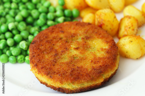 Vegetarian burger with fried potatoes and green peas
