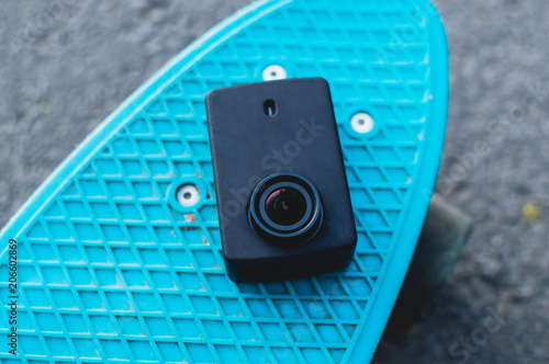Action camera on the blue plastic penny skateboard. Top view. The concept of modern culture, penny skateboarding, outdoor activity, modern lifestyle.