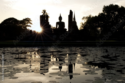 une silhouette du bouddha lors d’un magnifique couché de soleil dans le parc historique de Sukhothai 