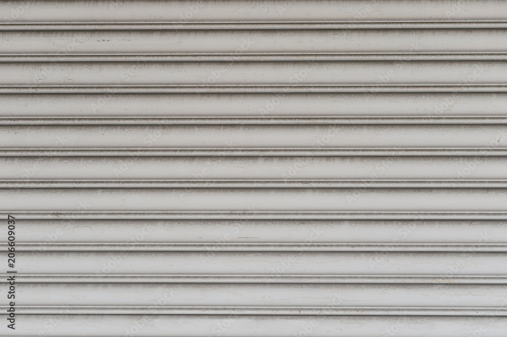 A closeup shot of automatic metal roller door used in factory, storage, garage, and industrial warehouse. The corrugated and foldable metal sheet offer space saving and provide urban and rustic feel A closeup shot of automatic metal roller door used in factory, storage, garage, and industrial warehouse. The corrugated and foldable metal sheet offer space saving and provide urban and rustic feel