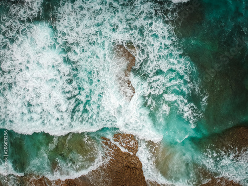 Aerial view of ocean waves and brown rocks in the coastline © nvphoto