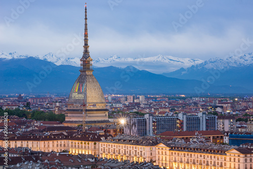 Turin skyline at dusk, panorama cityscape with the Mole Antonelliana showing "International Book Fair 2018" sign. Scenic colorful light and dramatic sky.