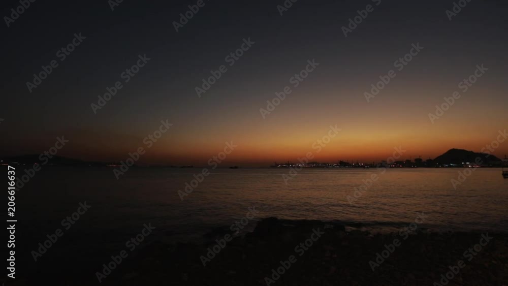 Shenzhen, China - Shekou-Chiwan cargo port at evening. Sea waves in foreground with burning sky in background Shenzhen, China - Shekou-Chiwan cargo port at evening. Sea waves in foreground with burning sky in background