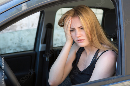 young female driver with headache in a car © Adam Gregor