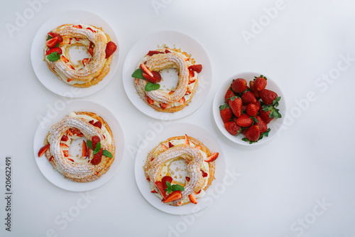 Cakes Paris Brest with strawberries, mint on white table