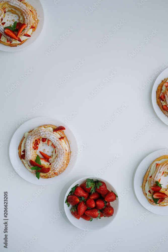 Cakes Paris Brest with strawberries, mint on white table Cakes Paris Brest with strawberries, mint on white table