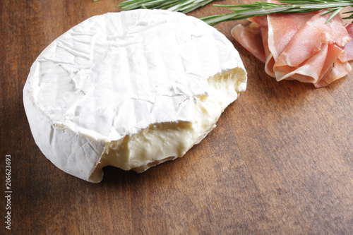 cheese brie and prosciutto jamon ham wooden background rosemary