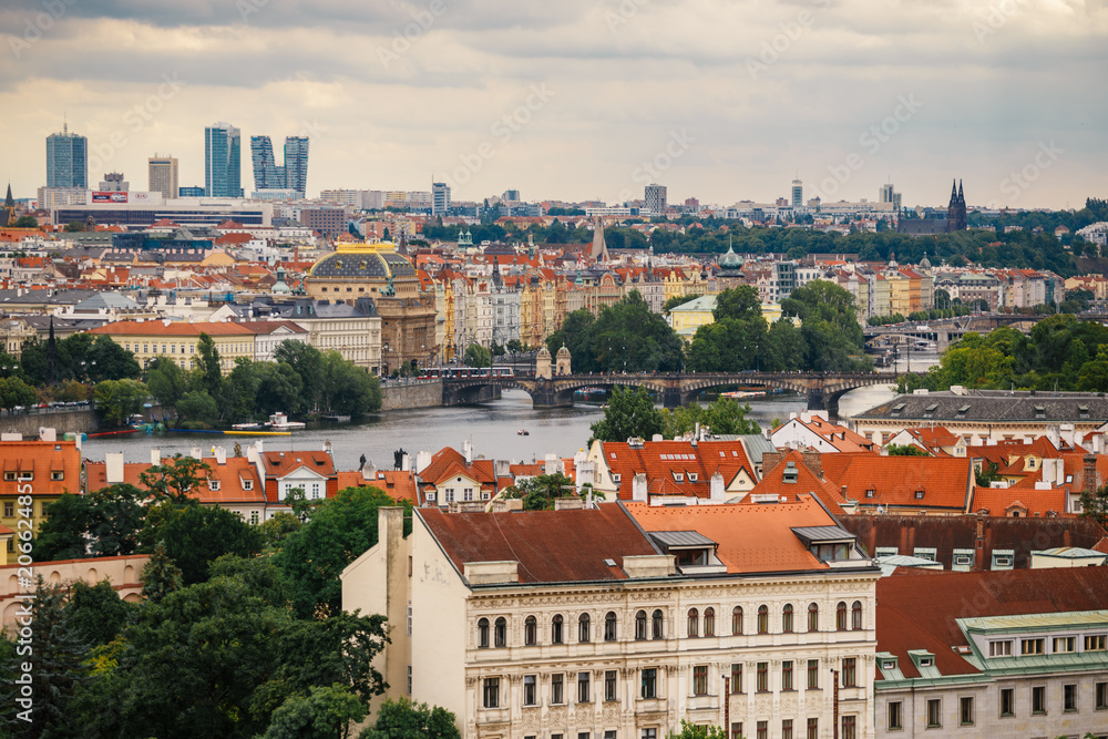 Fototapeta premium Czech Republic, Prague, July 25, 2017: Panoramic view of the city. Red Roofs of houses and structures of the old city in the summer in cloudy cloudy weather