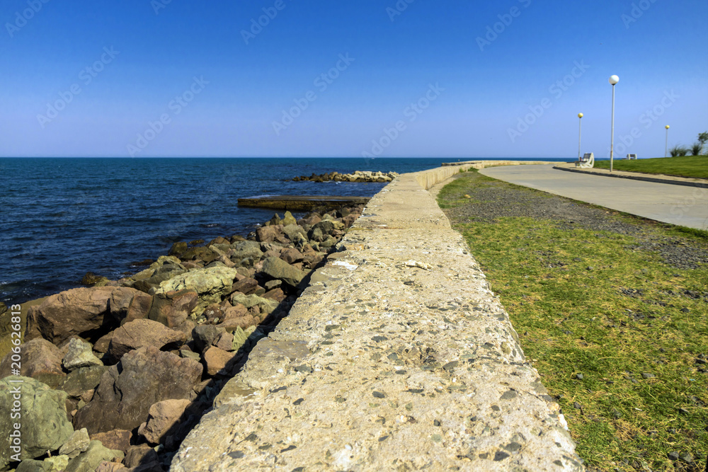 stone border of the sea embankment in the distance