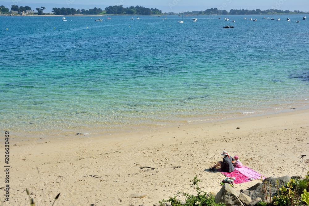 Une femme et sa fille sont assises sur une plage de Bretagne Une femme et sa fille sont assises sur une plage de Bretagne
