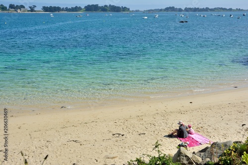 Une femme et sa fille sont assises sur une plage de Bretagne
