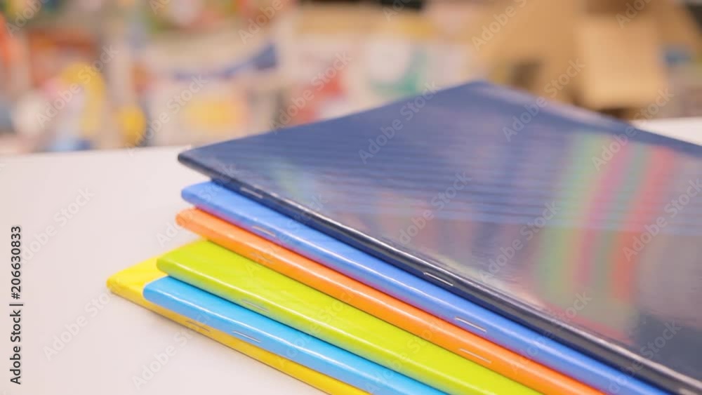 The hands of a stationery shop owner checking the spine of a bunch of colorful notebooks and dropping them on the counter.
The hands of a stationery shop owner checking the spine of a bunch of colorful notebooks and dropping them on the counter.