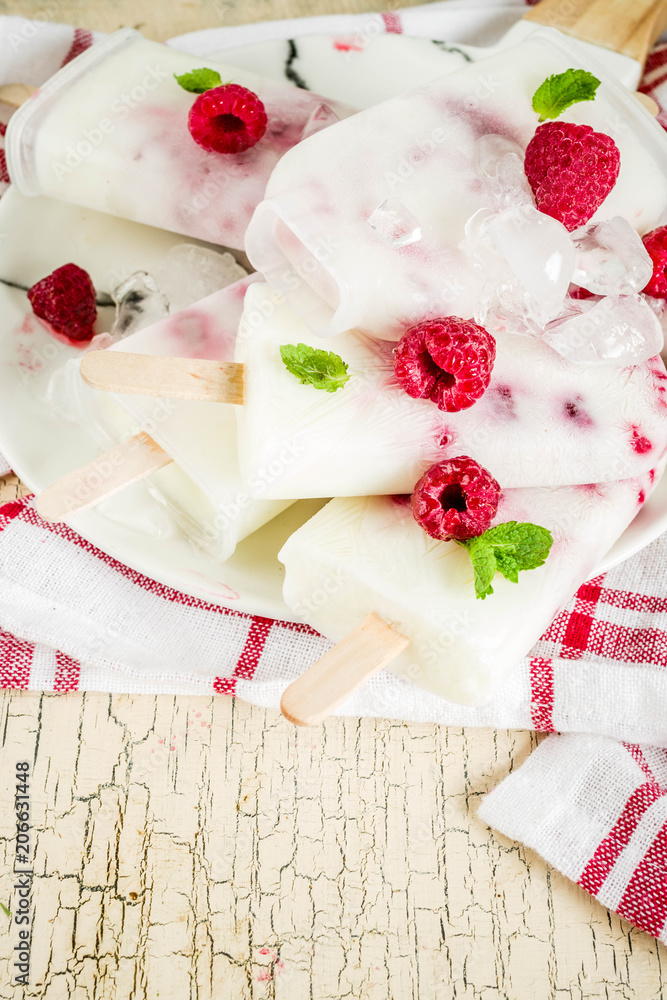 Summer sweet desserts, homemade organic ice cream popsicles from raspberry and yogurt, light beige background copy space Summer sweet desserts, homemade organic ice cream popsicles from raspberry and yogurt, light beige background copy space