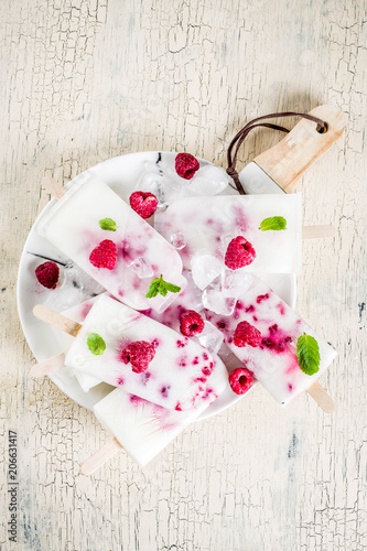 Fototapeta Naklejka Na Ścianę i Meble -  Summer sweet desserts, homemade organic ice cream popsicles from raspberry and yogurt, light beige background copy space