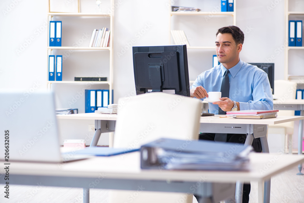 Obraz premium Handsome businessman employee sitting at his desk in office
