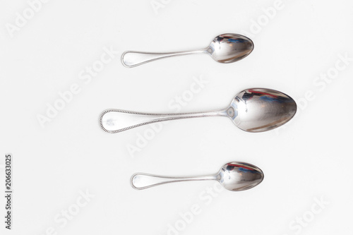 Set of small and big spoons on a white background in a studio