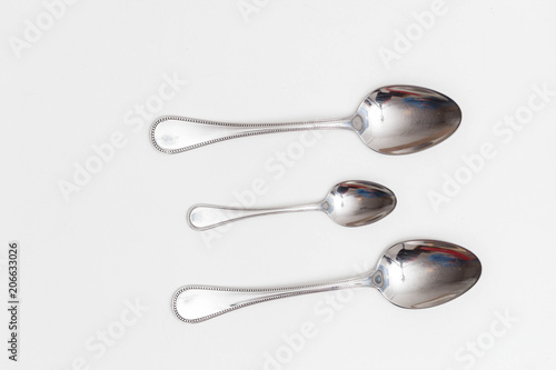 Set of small and big spoons on a white background in a studio