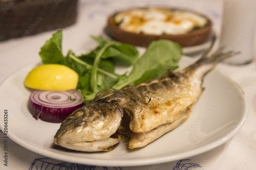 Seabream on the plate at the dinner table. Seabream on the plate at the dinner table.